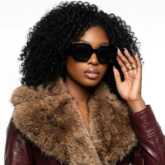 Woman wearing a fur-lined coat and sunglasses with a neutral background