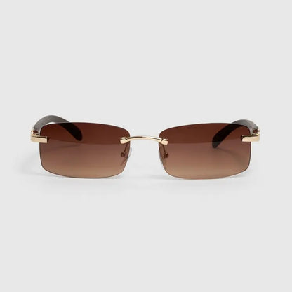 Sunglasses with gold frame and brown lenses on a light gray background