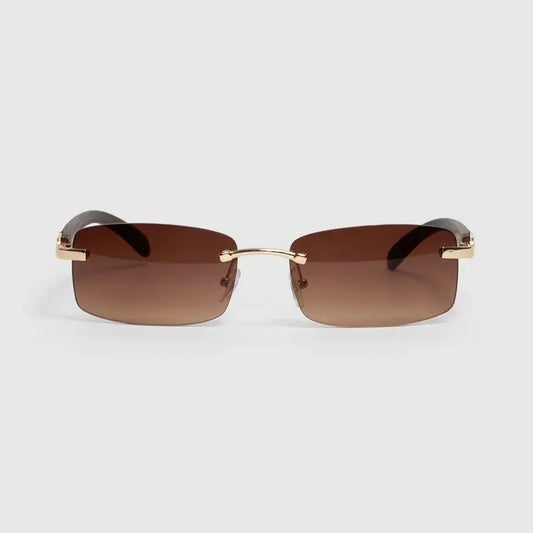 Sunglasses with gold frame and brown lenses on a light gray background