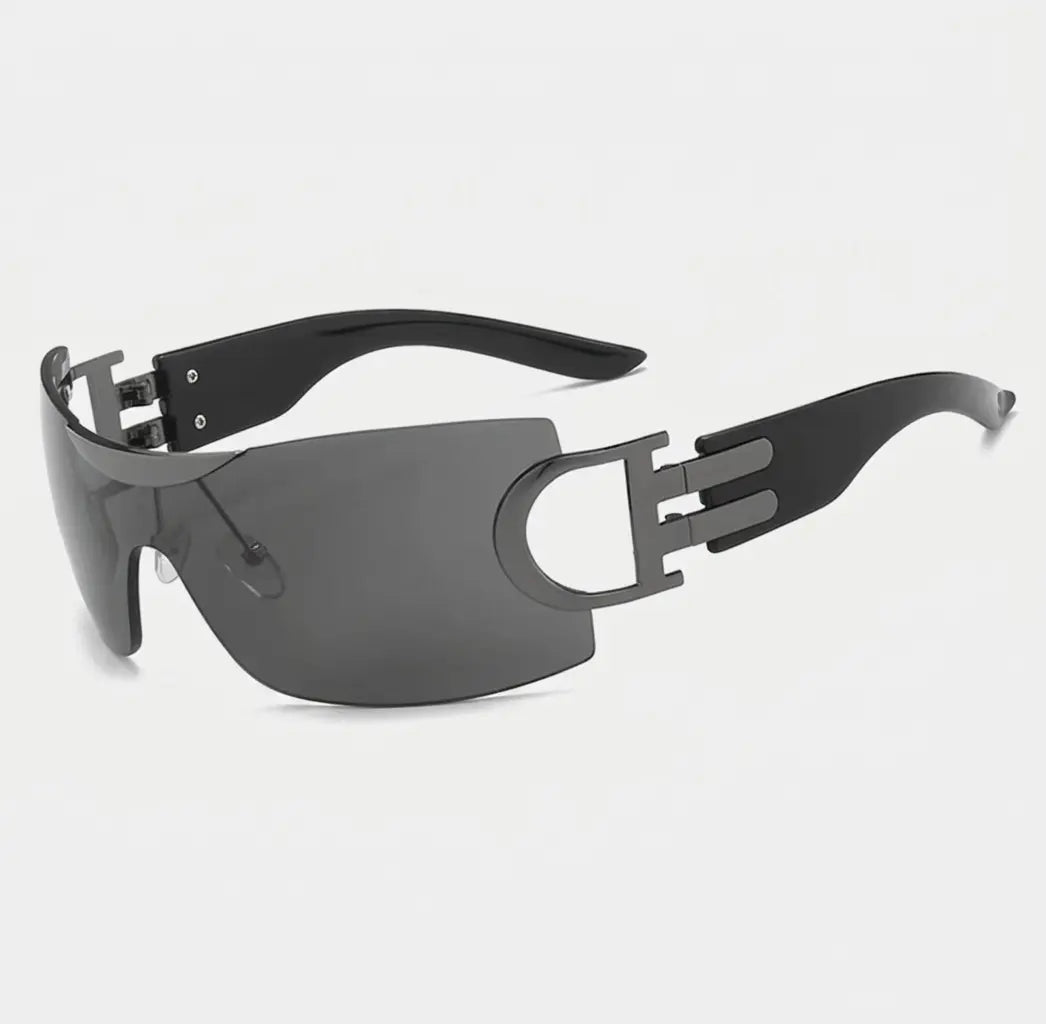 Rimless shield-style sunglasses with dark gray lenses, gunmetal side accents, and black arms displayed on a light gray background.