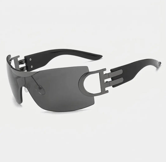 Rimless shield-style sunglasses with dark gray lenses, gunmetal side accents, and black arms displayed on a light gray background.
