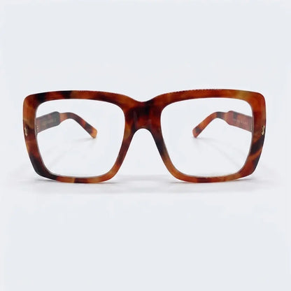 A pair of oversized plastic frame sunglasses with clear lenses and a patterned design.