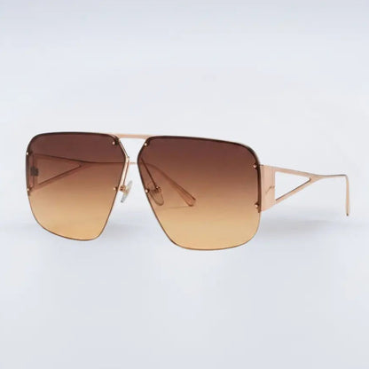 Sunglasses with gold frame and brown gradient lenses on a light gray background