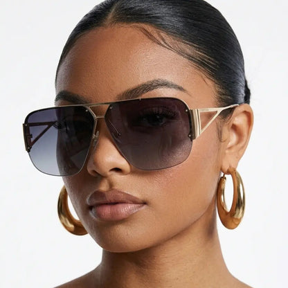 Woman wearing large hoop earrings and sunglasses on a white background