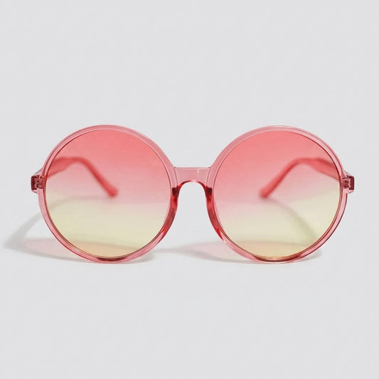 Round sunglasses with a translucent pink frame and pink-to-yellow gradient lenses displayed on a light gray background.