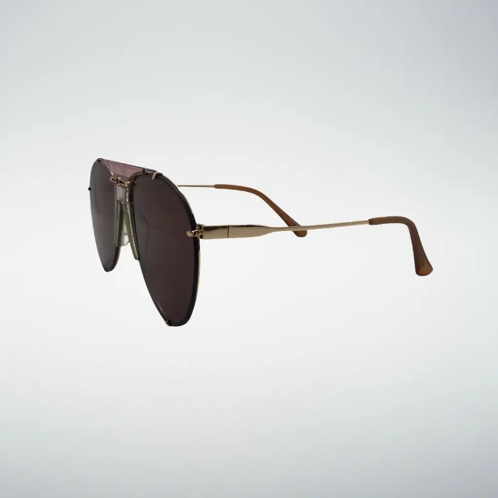 A pair of aviator-style sunglasses with dark pink lenses and slim gold metal temples, shown from a side profile against a light gray gradient background.