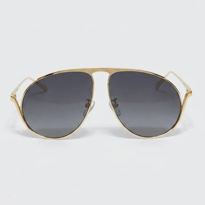 Gold-framed sunglasses with dark lenses on a light gray background