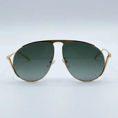 Gold-framed sunglasses with green gradient lenses on a light gray background