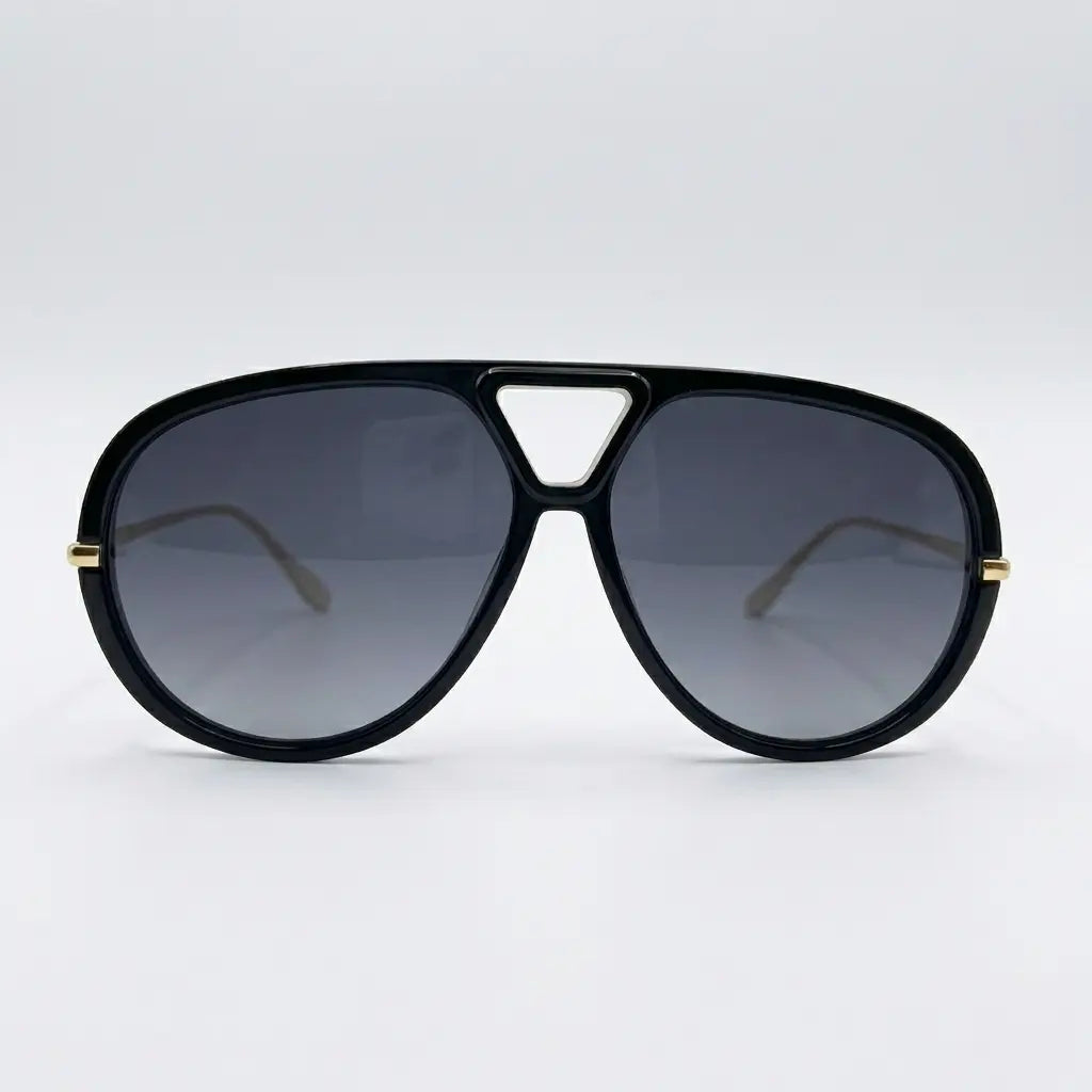 Oversized aviator-style sunglasses with a black frame, black lenses, and thin gold metal arms displayed on a light gray background.